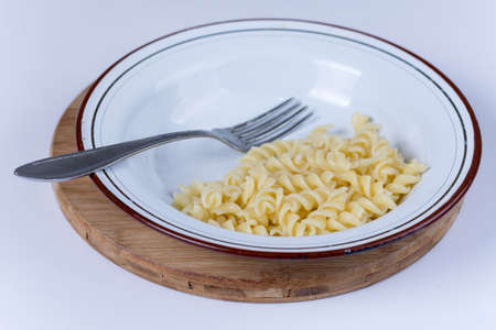 Cooked macaroni served in the plate over white.の写真素材