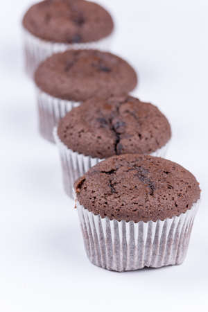 Brown chocolate muffins arranged over white background.の写真素材