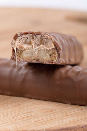 Chocolates filled with cream on the wooden board.