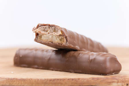 Chocolates filled with cream on the wooden board.