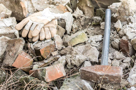 Working gloves with big hammer over ruins.の写真素材