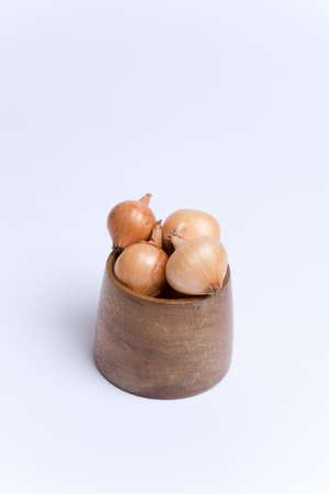 Onion bulbs in the wooden bowl ready for planting.の写真素材