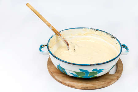 Mixed dough in the metal bowl isolated over white.の写真素材