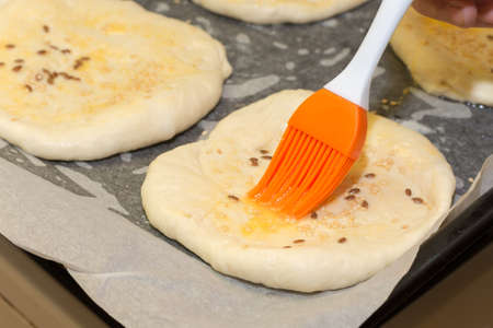 Coating the dough with the egg yolk and brush.の写真素材