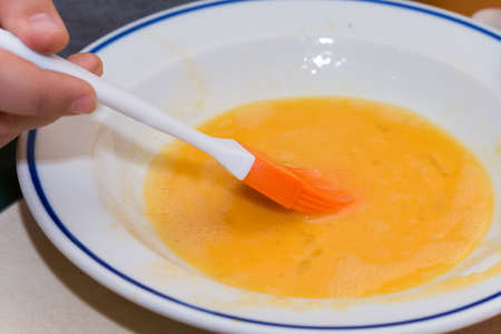 Brush with the egg yolks in a plate.の写真素材