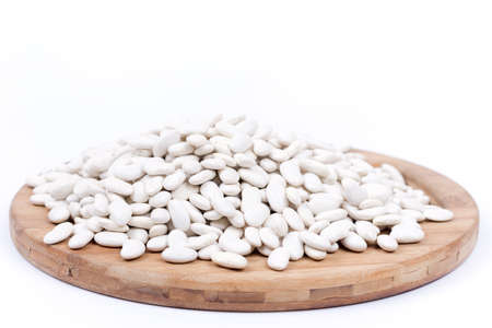 Raw white beans on the kitchen board. Copy space white background.の写真素材