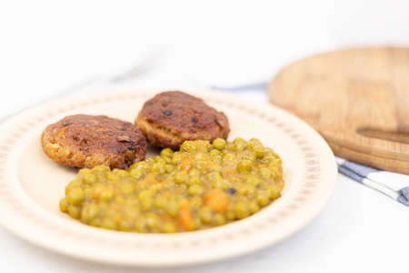 Served fried meatballs with cooked peas on the plate.