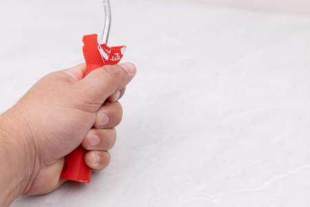 Male hand with painting brush above white background with copy space.