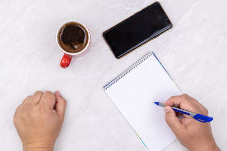 Top view male hands business workspace empty copy space notepaper mobile phone.