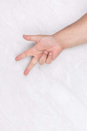 Isolated hand above white background with three fingers sign.