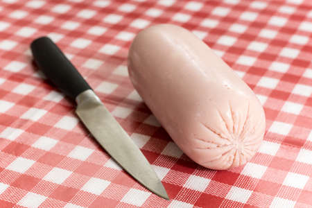 Bologna salami on the table with knifeの写真素材