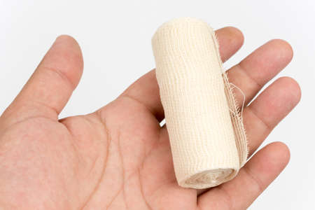 Hand holding bandage roll over white backgroundの写真素材