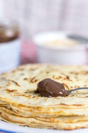 Chocolate cream on the spoon with blurred background