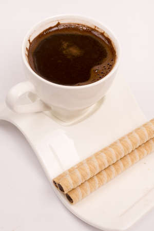 White cup of coffee with wafer chocolate cream rollsの写真素材