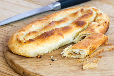 Sliced burek with meat on the wooden board. Rustic food.の写真素材