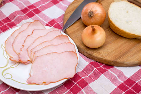 Cured meat served with onions on the cutting boardの写真素材