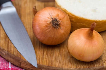 Onions on the wooden cutting boardの写真素材
