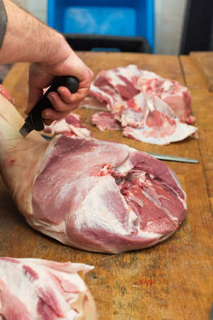 Butcher cutting raw pork meat.の写真素材