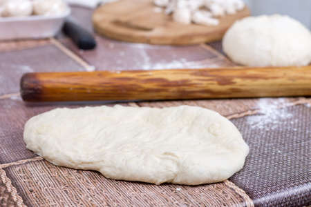 Raw dough on the table with rolling pin