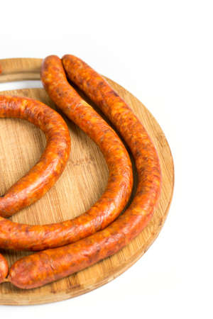 Raw homemade domestic sausage on the wooden board. Isolated over white background.