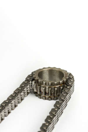 Used oiled timing chain on crang shaft isolated over white background.