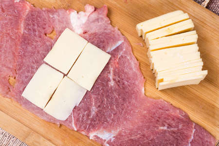 Preparing pork chop stuffed with yellow cheeseの写真素材