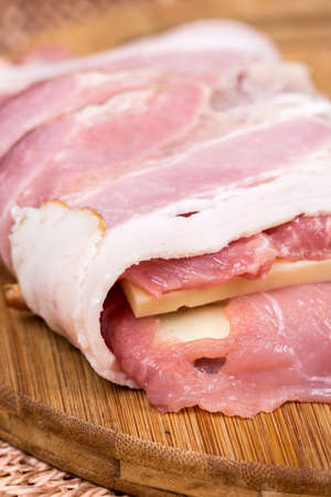 Closeup macro view stuffed meat with yellow cheese in baconの写真素材