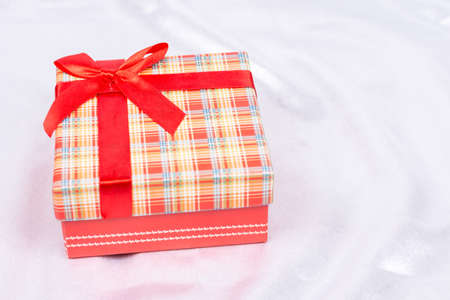 Gift box with bow over white satinの写真素材