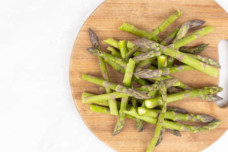 Cooked asparagus on the wooden board.