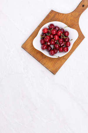 Cherries in the bowl with copy space above table.の写真素材
