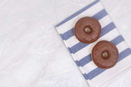 Top view of table with chocolate donuts on the kitchen dish cloths.の写真素材