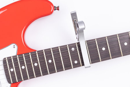 Electric Guitar with Capodastro isolated above white background.