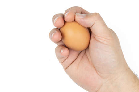 Raw chicken egg in the hand with copy space above white background.の写真素材