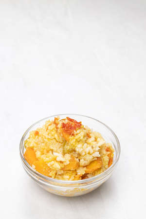 Risotto served in the bowl above white background.の写真素材