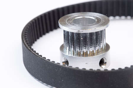 Aluminum pulley with timing belt for cnc machines above white background.の写真素材