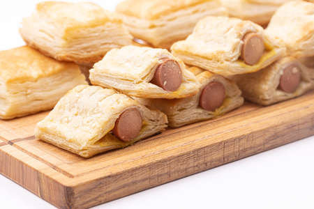 Puff pastry on the serving wooden board isolated above white background.の写真素材