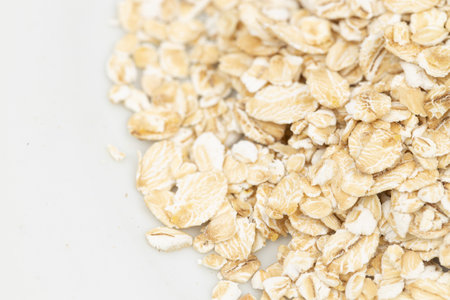 Dry rolled oatmeal in bowl isolated on white background. Top viewの写真素材