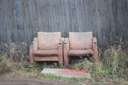 two old chairs amid rustic fence - symbolize the sunset two lives, two lives.の写真素材