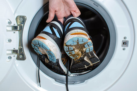 Washing dirty sneakers in the washing machine. Cleaning trail running shoesの写真素材