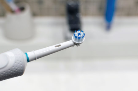 Rechargeable, electric toothbrush, close-up. Against the backdrop of a bathroom in white.の写真素材
