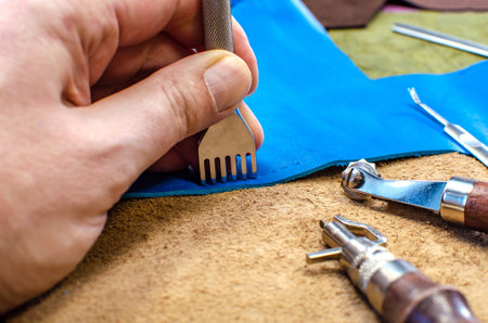 Leather goods manufacturing process. Tools for sewing bags, wallets, clutches. Colored pieces of...