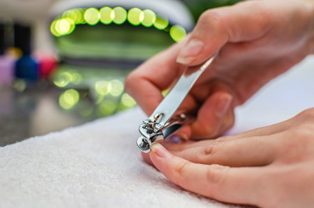 Woman cutting nails with nail clippers - close-up. Home nail careの写真素材
