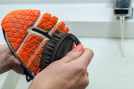 Cleaning dirty sneakers after training. Wash dirty sneakers. Wash your sneakers. Cleaning your trail running shoeの写真素材