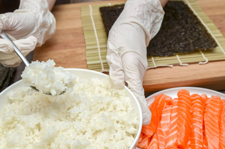 Using rice for sushi, the process of making sushi with salmon and avocadoの写真素材