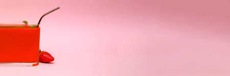 strawberry smoothie on a pink background, with a metal cocktail strawの写真素材