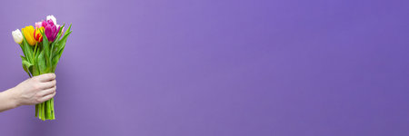 A bouquet of flowers in a mans hand on a purple background. Congratulations on the holiday, March 8,...