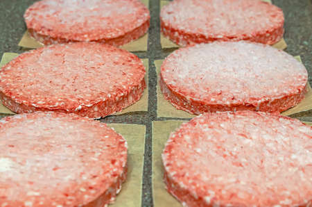 Frozen burger meat on table before grilling, defrost before grillingの写真素材