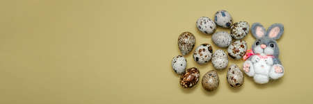 Postcard for Easter. Blank for a postcard with a place to insert text. Easter plush bunny and quail eggs on yellow backgroundの写真素材