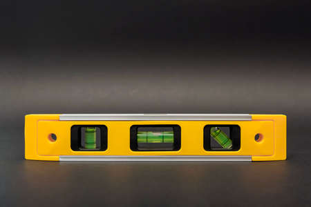 Building level in yellow on a black background. Construction tool, printable for postcard or poster, place for textの写真素材