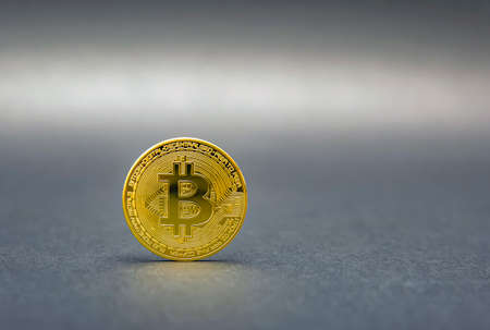 Bitcoin symbol in gold color on a black background. The concept of crypto currencies as the future of the economy.の写真素材